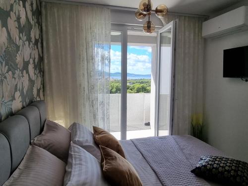 um quarto com uma cama e uma grande janela em Apartment "50 Shades" with balcony and free parking in the garage em Zadar