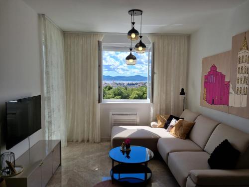 a living room with a couch and a window at Apartment "50 Shades" with balcony and free parking in the garage in Zadar