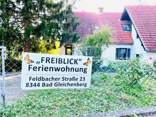 un cartel en una valla delante de una casa en Freiblick 3 Bad Glbg mit Terrasse Top 3, en Bad Gleichenberg