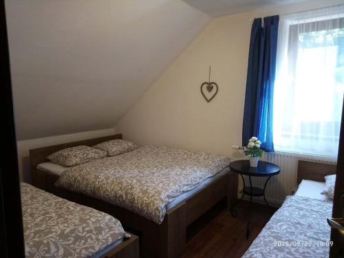ein Schlafzimmer mit 2 Betten und ein Fenster mit einem Herz an der Wand in der Unterkunft Chalupa Maršíkov 120 in Velké Losiny