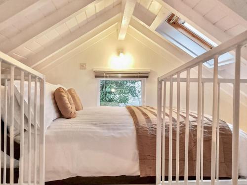 a white bed in a room with a window at The Hazeling Hideaway in Stroud