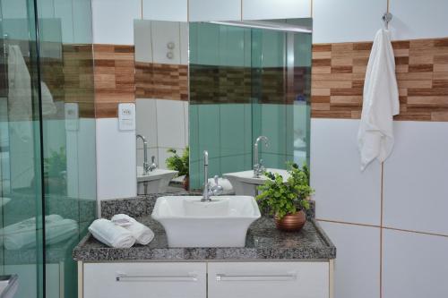 a bathroom with a sink and a glass wall at Hotel Açay in Santarém