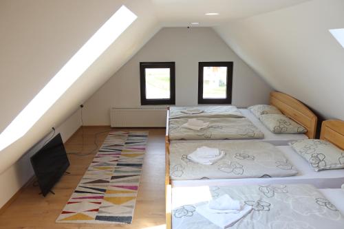 um quarto no sótão com 3 camas e uma televisão em Vila Ana em Travnik