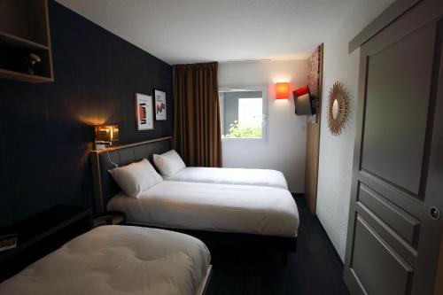 a hotel room with two beds and a window at greet La Teste Bassin d'Arcachon in La Teste-de-Buch