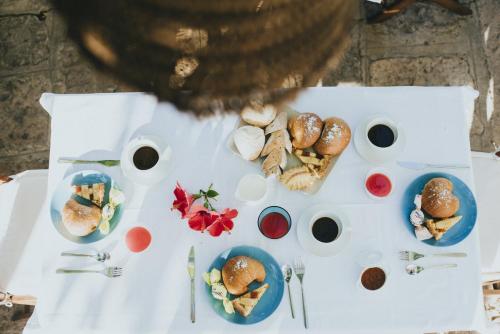 a white table with plates of food on it at B&B Sa Cruxitta in Portoscuso