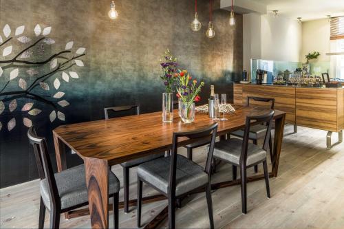 een eetkamer met een houten tafel en stoelen bij KeizersgrachtSuite471 in Amsterdam