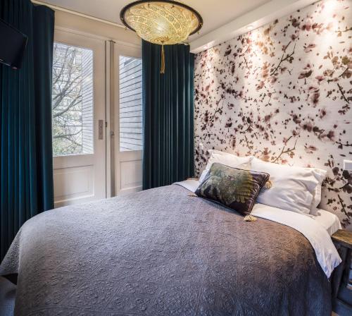 1 dormitorio con 1 cama con pared de flores en KeizersgrachtSuite471 en Ámsterdam