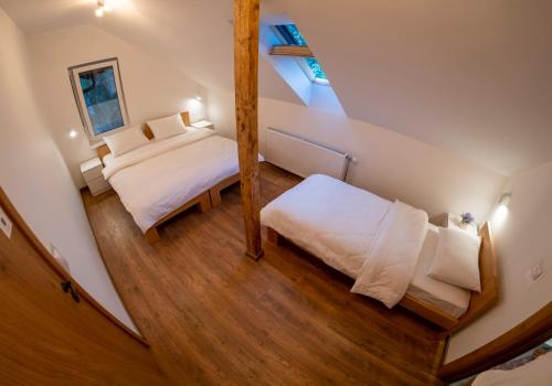 a attic bedroom with a bed and a mirror at Petlov salaš rooms in Novi Sad
