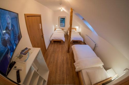 Habitación pequeña con 3 camas y escalera. en Petlov salaš rooms en Novi Sad