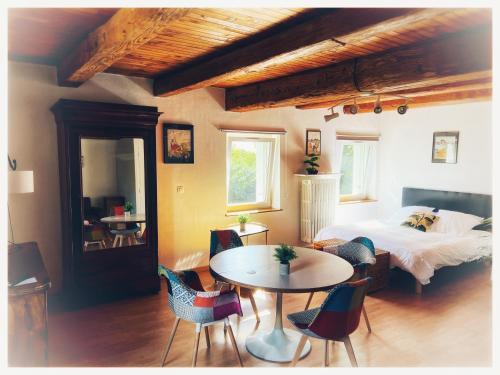 - une chambre avec un lit, une table et des chaises dans l'établissement Château de Logne, à Ay-sur-Moselle