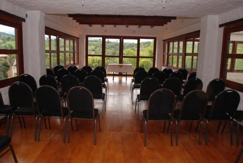a room with chairs and a table and windows at San Agustin Internacional Hotel in San Agustín