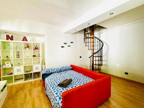 a red couch in a room with a staircase at Casetta Nica in Torvaianica