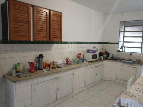 a kitchen with a counter top with a microwave at Hostel Cachoeira in Porto Alegre