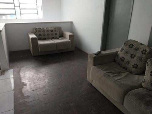 a living room with a couch and a chair at Hostel Cachoeira in Porto Alegre