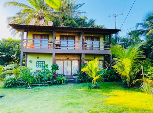 una casa con palmeras delante en Carpe Diem Suítes Taipu de Fora, en Maraú