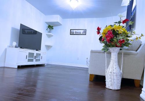 una sala de estar con un jarrón con flores. en WELCOME TO PREMIUM LIVING PLACE / 2 BEDROOMS SUITE, en Innisfil