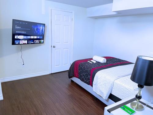 a bedroom with a bed and a flat screen tv at WELCOME TO PREMIUM LIVING PLACE / 2 BEDROOMS SUITE in Innisfil