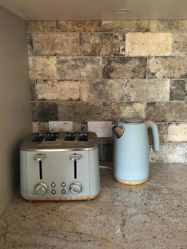 a toaster and a coffee pot sitting on a counter at River View Cottage in Kahuranaki