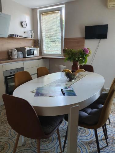a kitchen with a table with chairs and a vase of flowers at Batala1-City marina apartment with secured private parking in Dubrovnik