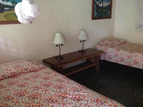 a room with two beds and two lamps on tables at Piscina Natural on the Sea in Cahuita
