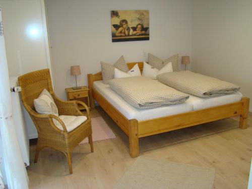 2 Betten in einem Zimmer mit einem Stuhl und einem Tisch in der Unterkunft Schöne Ferienwohnung im Nationalpark nördlicher Schwarzwald in Forbach