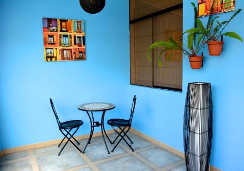 a table and chairs in a room with a blue wall at Hotel Villa Jazmin in Ica