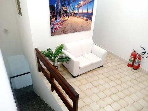 sala de estar con sofá blanco y planta en Pousada Sol e Mar de Pajuçara, en Maceió