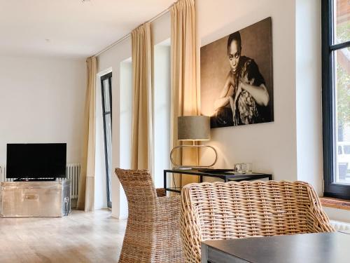 uma sala de estar com um sofá de vime e uma televisão em SEEBADHOF Berlin-Rangsdorf em Rangsdorf