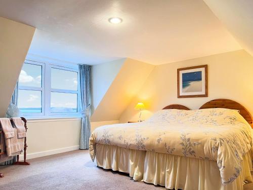 a bedroom with a bed and a large window at Grieves Cottage in Arnisdale