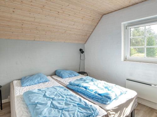 two twin beds in a room with a window at Holiday home Væggerløse XXXVIII in Marielyst