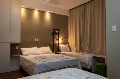 a hotel room with two beds with towels on them at Hotel Pousada Santa Maria in Aparecida