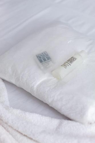 a white bed with two white towels on it at Hotel Pousada Santa Maria in Aparecida