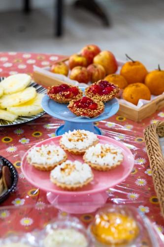 a table with plates of pastries and fruit on it at Hotel Pousada Santa Maria in Aparecida