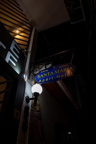a santa maria apartment hotel sign on the side of a building at Hotel Pousada Santa Maria in Aparecida