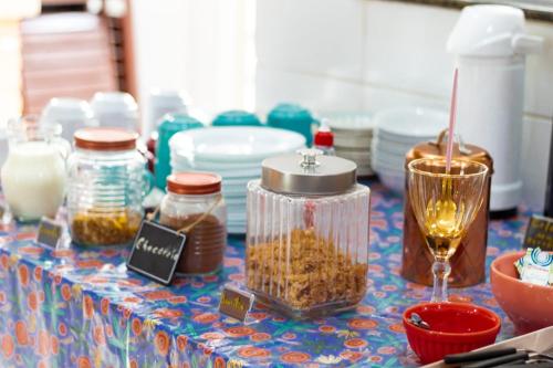 a table with jars of food and a wine glass at Hotel Pousada Santa Maria in Aparecida