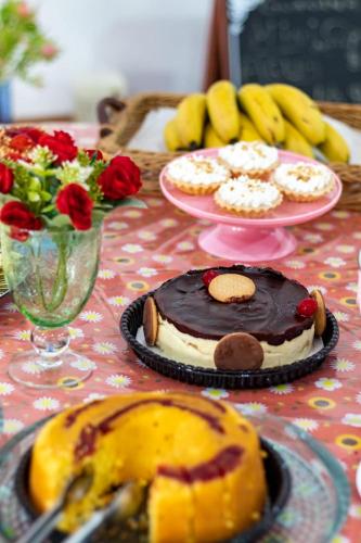 a table with a cake on a table with flowers at Hotel Pousada Santa Maria in Aparecida