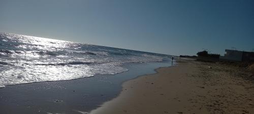 a sandy beach with the ocean in the background at Oblò sul Mare - Villa nel cuore del Salento in Lendinuso