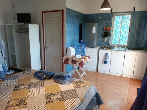 a kitchen with a table with a quilt on it at cabañas Te Pito Kura in Hanga Roa