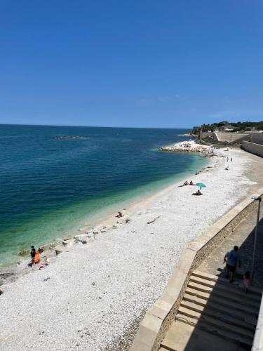 una spiaggia con persone sdraiate sulla sabbia e sull'acqua di Scoglierauno a Bisceglie