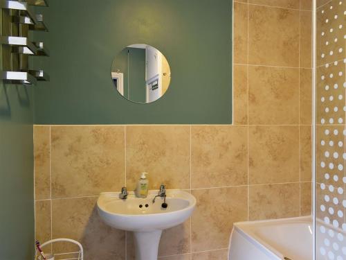a bathroom with a sink and a mirror at Woodville in Porthmadog