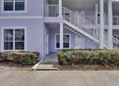 a white building with a staircase in front of it at Huge Screened Patio That Overlooks Lake Buck, Near Famous Attractions!! in Orlando