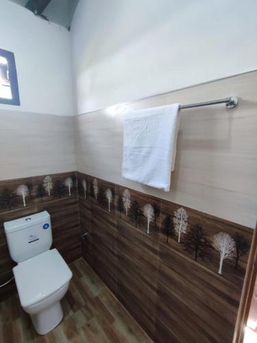 a bathroom with a toilet and a towel at Onara Guest in Anuradhapura