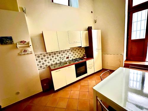 una cucina con armadietti bianchi e frigorifero di Lo scorcio del Borgo 2.0 ad Atrani