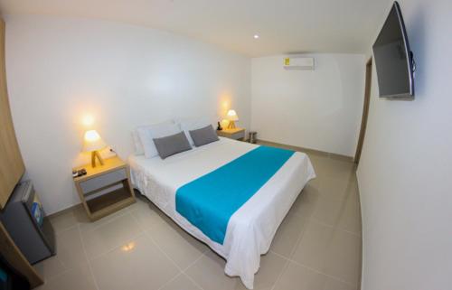 a bedroom with a large bed and a television at Hotel Boutique Laureles Medellin (HBL) in Medellín