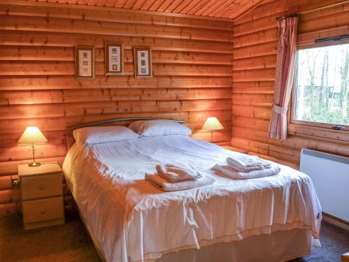 a bedroom with a bed in a log cabin at Cosy Lodge - Uk37418 in Legbourne
