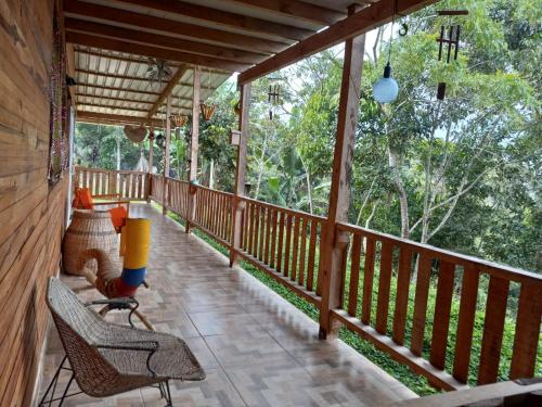 a porch of a wooden cabin with chairs and trees at LA CASA DEL BOSQUE Via SALADITO in La Elvira