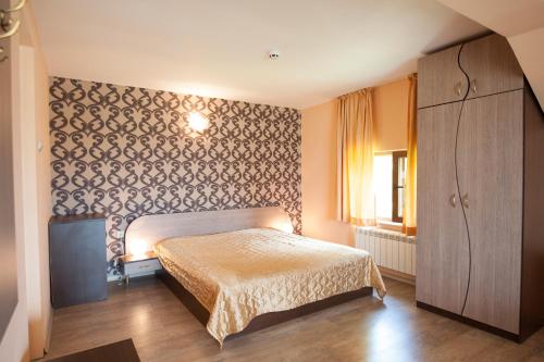 a bedroom with a bed and a dresser in it at Guest house Lidia in Tsigov Chark