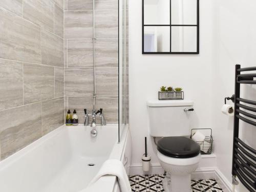 a bathroom with a tub and a toilet at Ty Kinik in Llangollen