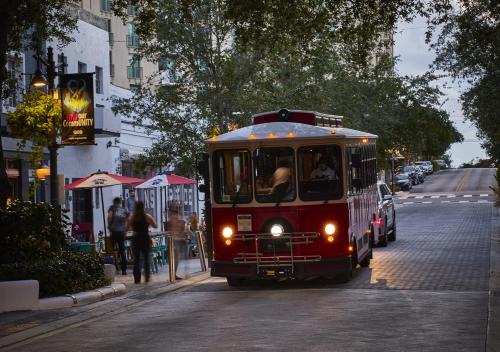 a trolley car driving down a city street at AKA West Palm in West Palm Beach