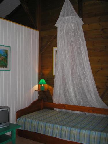 a bedroom with a bed with a net on it at GWAN THAZAR en Guadeloupe in Bouillante
